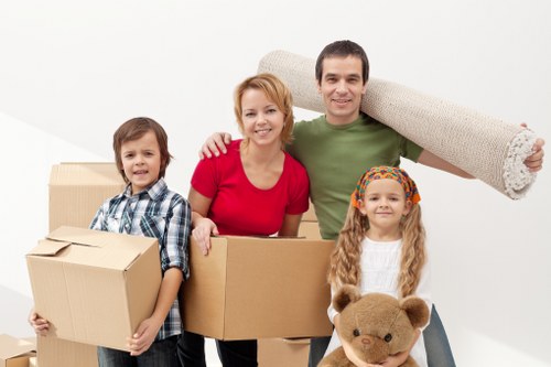 Commercial movers handling boxes and desks in a Tooting property